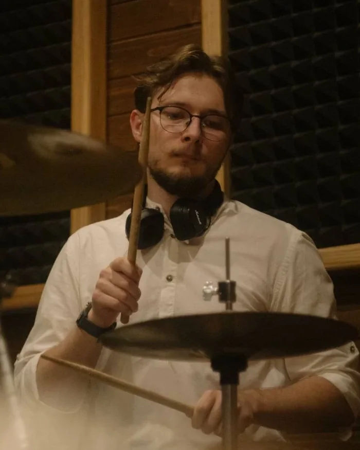 Nazarii playing drums in a rehearsal studio